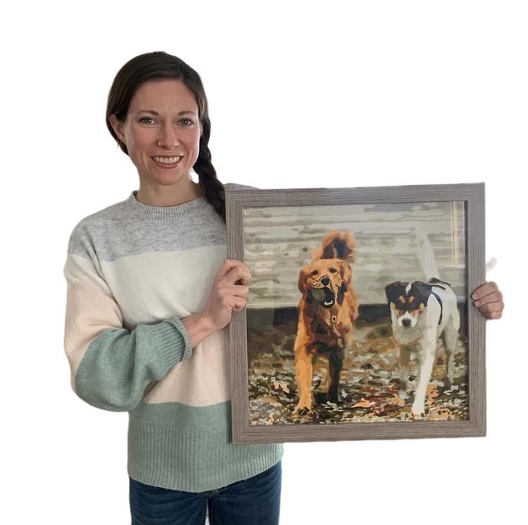 Kundin hält ihr personalisiertes Malen-nach-Zahlen Bild mit zwei Hunden in den Händen – handgemalt nach Foto